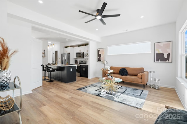 living room featuring light hardwood / wood-style flooring and ceiling fan