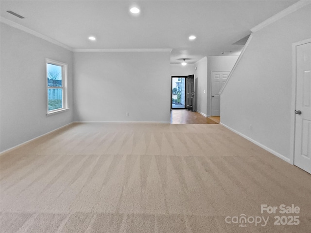 unfurnished living room featuring crown molding, light colored carpet, and a healthy amount of sunlight