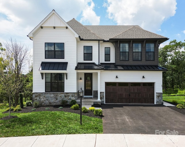 modern inspired farmhouse with a garage and a front lawn