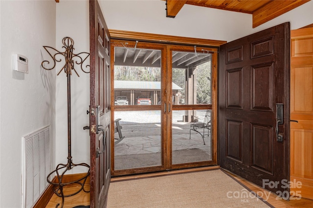 doorway to outside with beam ceiling