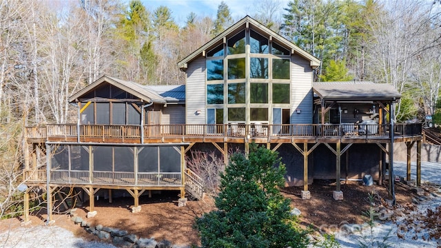 back of house with a sunroom and a deck