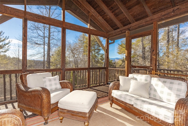 sunroom / solarium featuring wood ceiling, a healthy amount of sunlight, and vaulted ceiling with beams