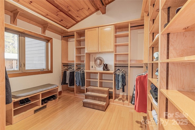 spacious closet with vaulted ceiling with beams and light hardwood / wood-style floors