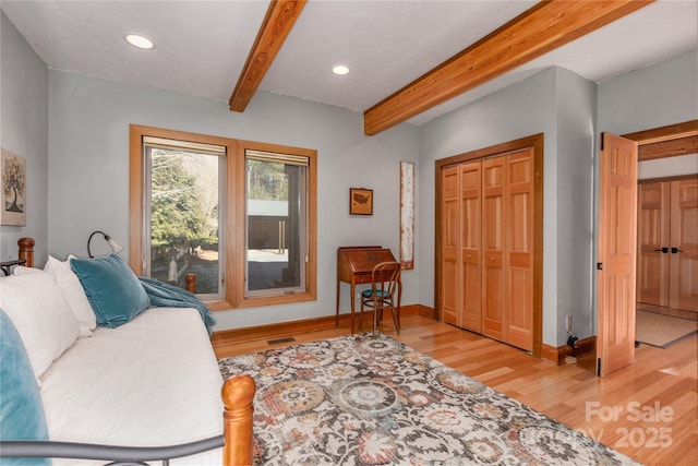 living room featuring beam ceiling and light hardwood / wood-style flooring