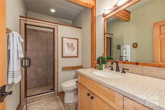 bathroom featuring tile patterned flooring, vanity, toilet, and a shower with shower door