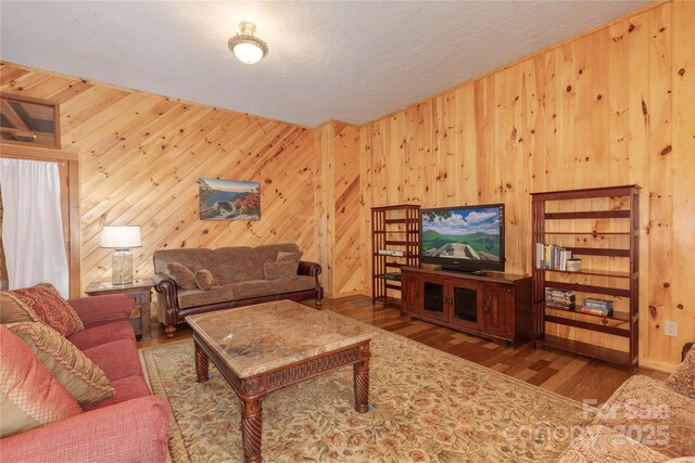 living room with wooden walls and hardwood / wood-style floors