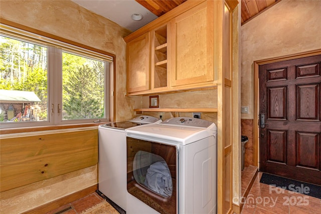 laundry room with separate washer and dryer and cabinets