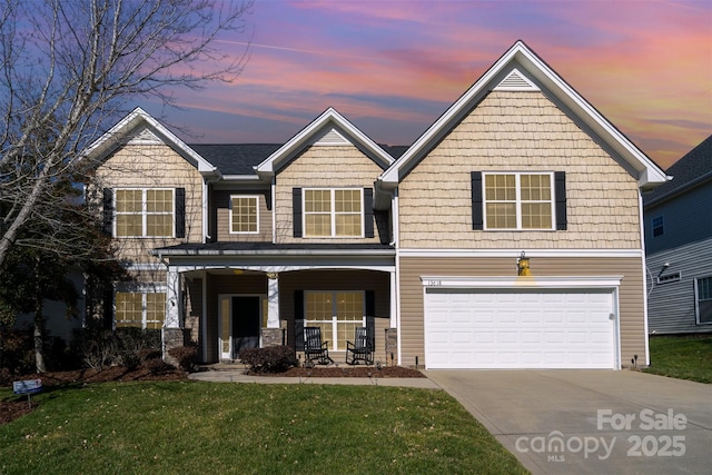 craftsman inspired home with a garage, covered porch, and a lawn