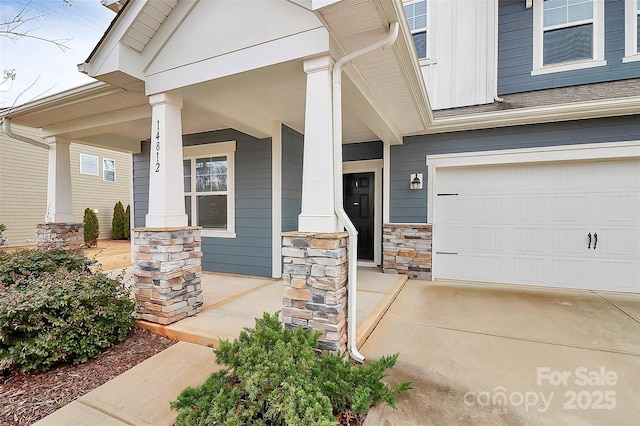 doorway to property with a garage and covered porch