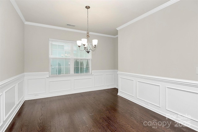 spare room featuring ornamental molding, a chandelier, and dark hardwood / wood-style flooring