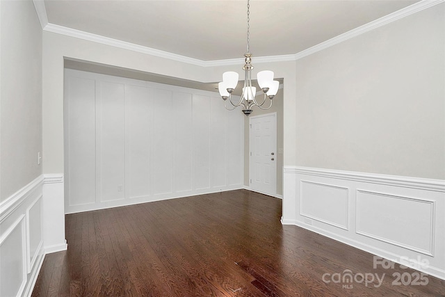 empty room featuring crown molding, dark hardwood / wood-style floors, and a notable chandelier