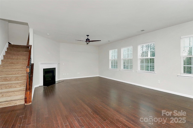 unfurnished living room with ceiling fan and dark hardwood / wood-style flooring