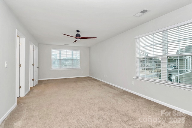 spare room with ceiling fan and light colored carpet