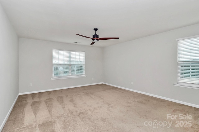 carpeted spare room featuring ceiling fan