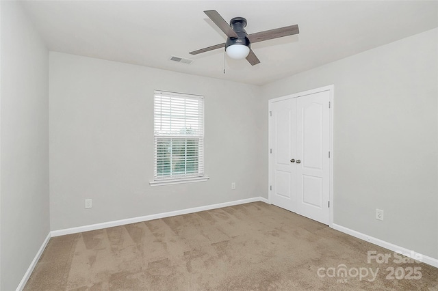 carpeted spare room featuring ceiling fan