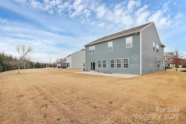 back of property with a yard and a patio