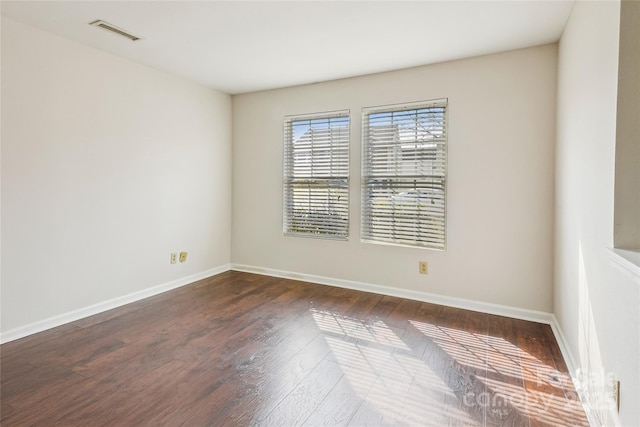 unfurnished room with dark wood-type flooring