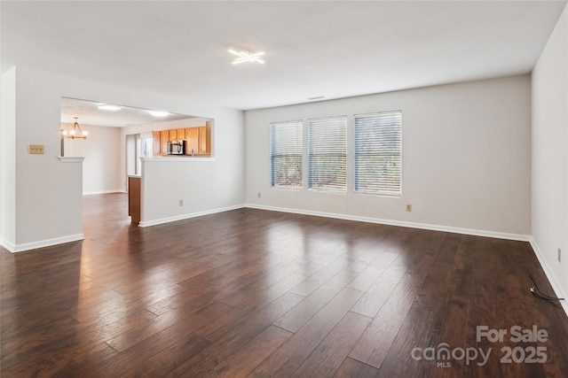 empty room featuring dark hardwood / wood-style floors and a notable chandelier