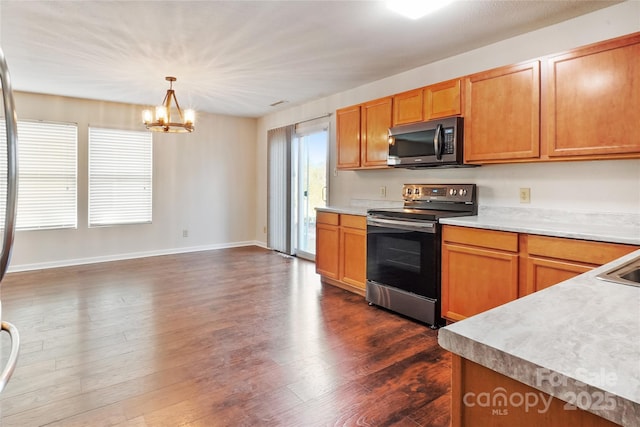 kitchen with sink, an inviting chandelier, appliances with stainless steel finishes, dark hardwood / wood-style flooring, and pendant lighting