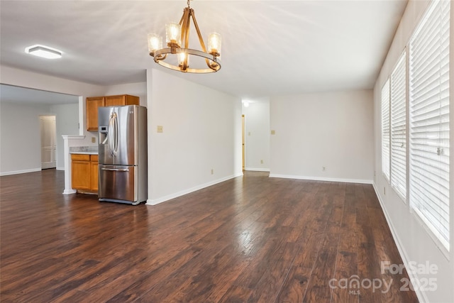 unfurnished living room with dark hardwood / wood-style flooring and a notable chandelier