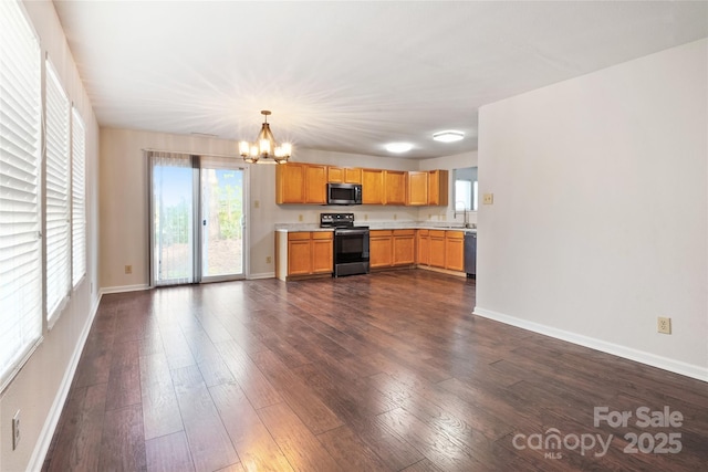 kitchen featuring pendant lighting, sink, electric range, dark hardwood / wood-style floors, and black dishwasher