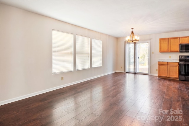 unfurnished living room with dark hardwood / wood-style flooring and a chandelier