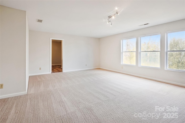 spare room featuring carpet floors and track lighting