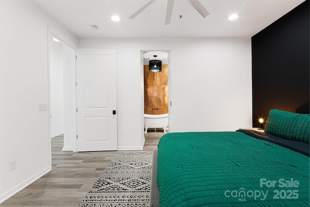 bedroom featuring connected bathroom, hardwood / wood-style flooring, and ceiling fan