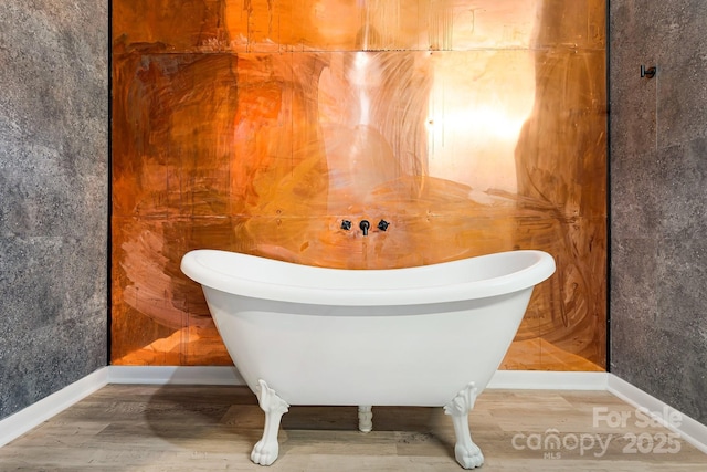 bathroom with wood-type flooring and a washtub