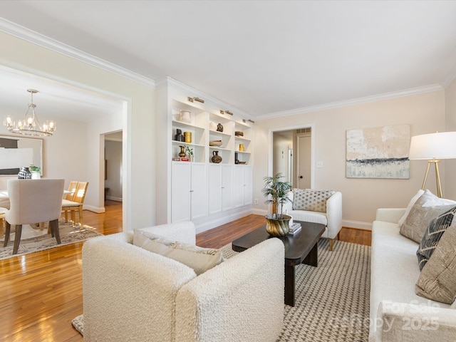 living room featuring an inviting chandelier, ornamental molding, and light wood-type flooring