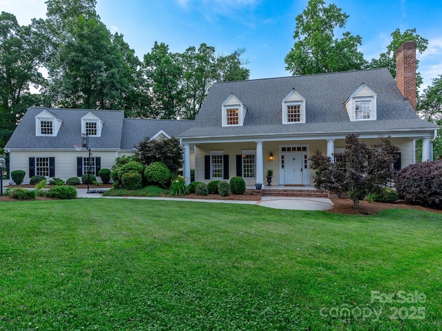 new england style home featuring a porch and a front lawn