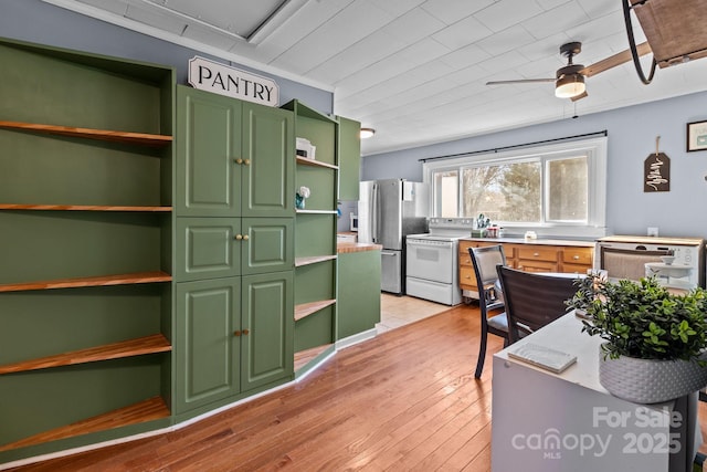 kitchen featuring light wood-type flooring, stainless steel fridge, white electric stove, green cabinets, and ceiling fan