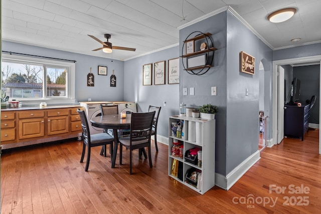 dining space with ornamental molding, light hardwood / wood-style floors, and ceiling fan