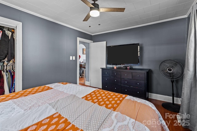 bedroom with ceiling fan, ornamental molding, hardwood / wood-style floors, and a closet