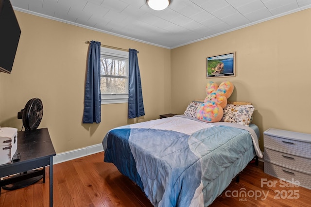 bedroom with crown molding and dark wood-type flooring