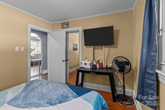 bedroom with dark wood-type flooring, ornamental molding, and a closet