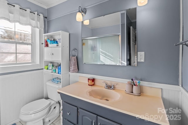 bathroom with a shower with door, vanity, and toilet