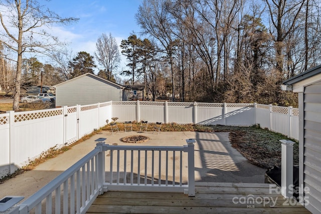 wooden deck with an outdoor fire pit and a patio area