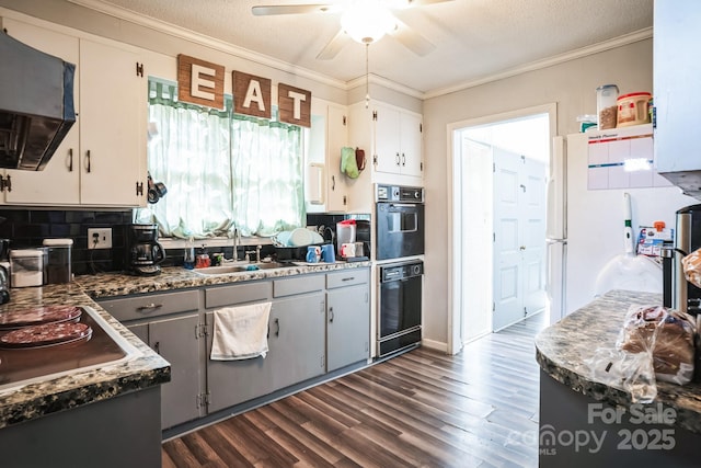 kitchen with white cabinetry, sink, extractor fan, and black appliances