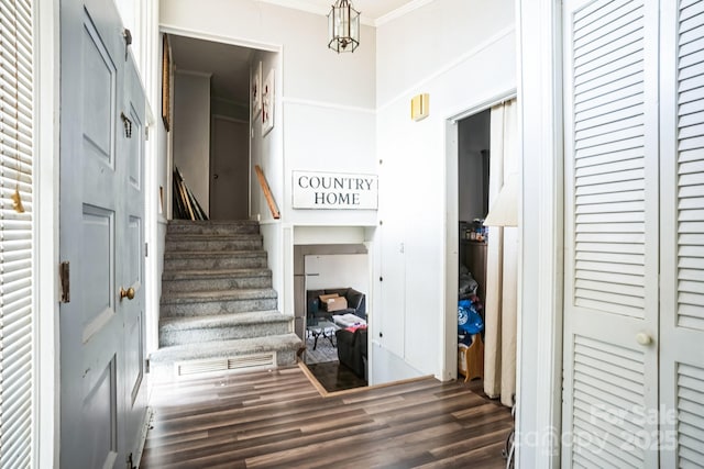 staircase with crown molding and hardwood / wood-style floors