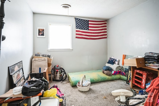 bedroom featuring a textured ceiling and carpet flooring