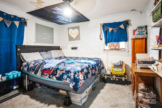 carpeted bedroom with a textured ceiling and ceiling fan