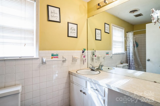 bathroom featuring vanity, tile walls, a shower with shower curtain, and toilet