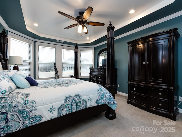 bedroom with a raised ceiling, crown molding, light carpet, and ceiling fan