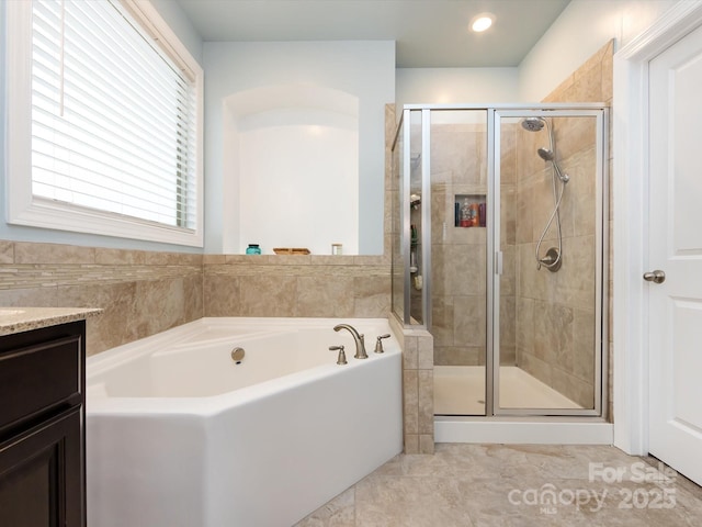 bathroom with vanity and independent shower and bath