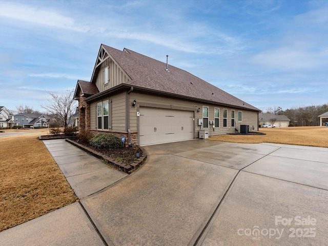 view of property exterior with a yard, a garage, and central AC