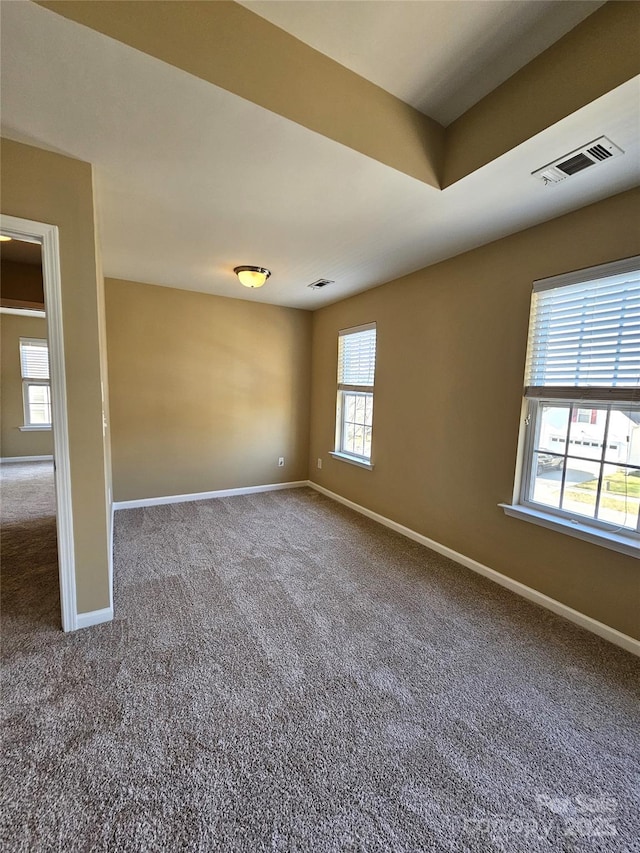 unfurnished room with carpet flooring, baseboards, and visible vents