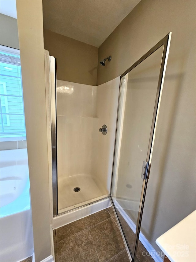 bathroom with tile patterned flooring and a shower stall