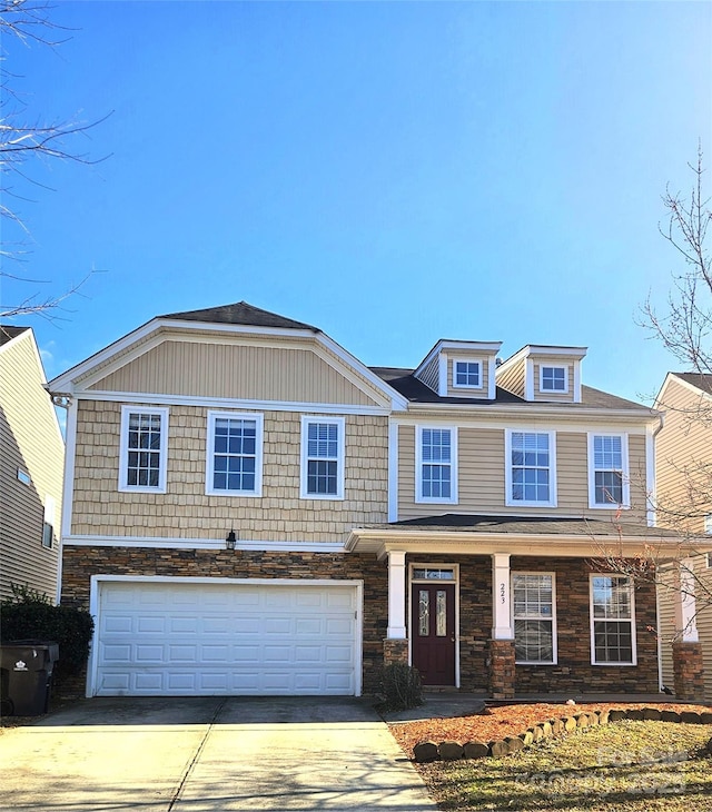 view of front facade featuring stone siding, concrete driveway, and a garage