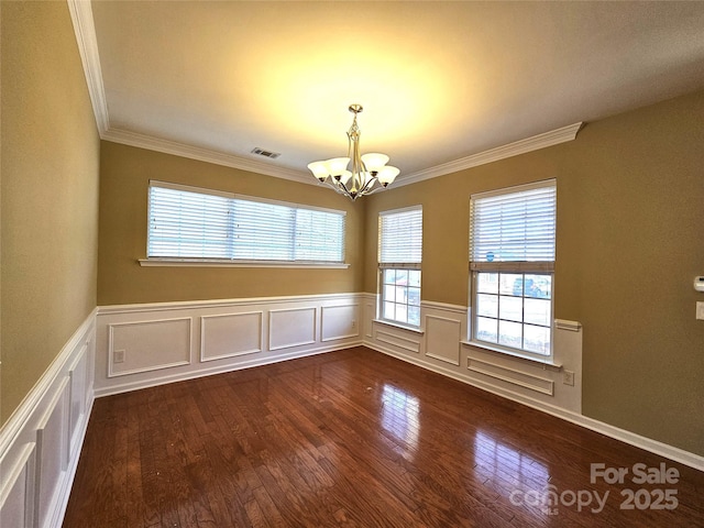 unfurnished room featuring dark wood-style floors, visible vents, a chandelier, and crown molding